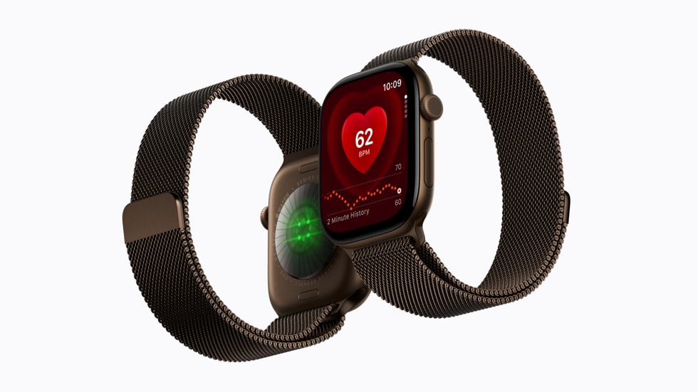 Dua Apple Watch Series 12 bertali logam, satu memperlihatkan sensor di bagian belakang dan satu menampilkan aplikasi detak jantung