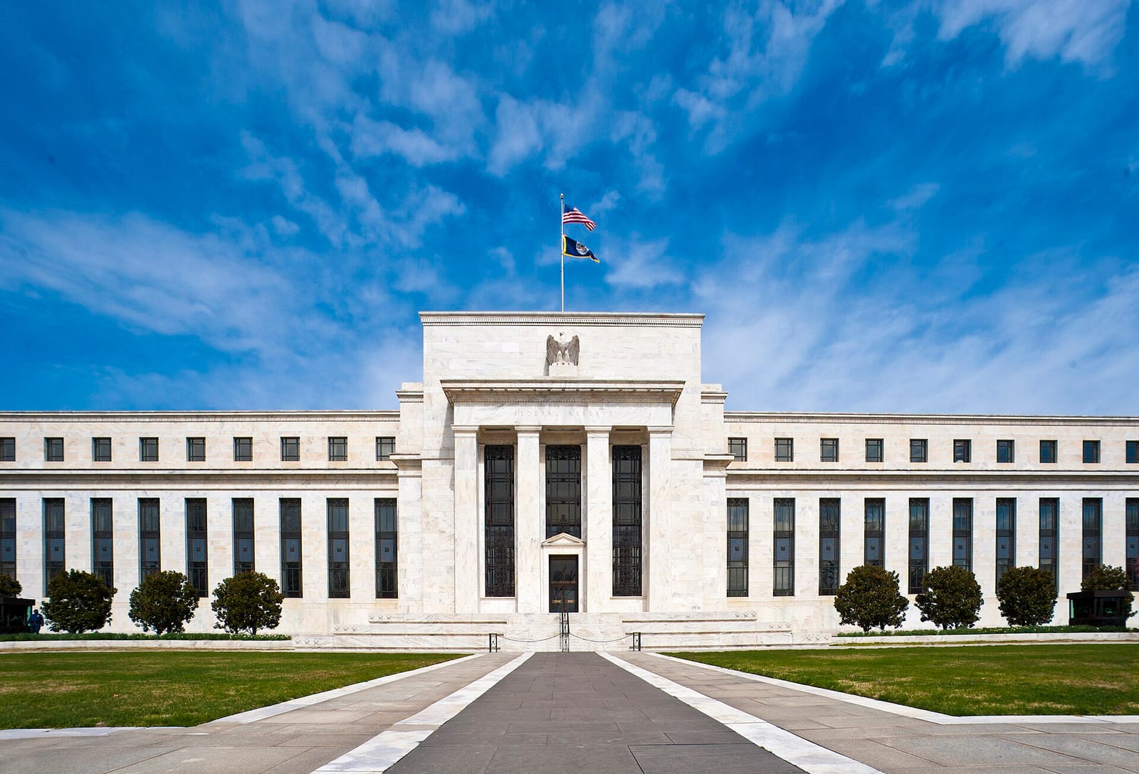 Gedung Marriner S. Eccles, kantor pusat Dewan Gubernur Federal Reserve di Washington, D.C., dengan bendera Amerika Serikat di atapnya